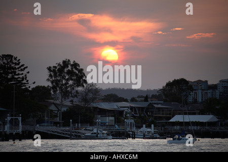 Coucher de soleil dans la lumière du soir au bord de l'eau plus de maisons près de Bulimba Point sur river Brisbane Queensland QLD Australie Banque D'Images