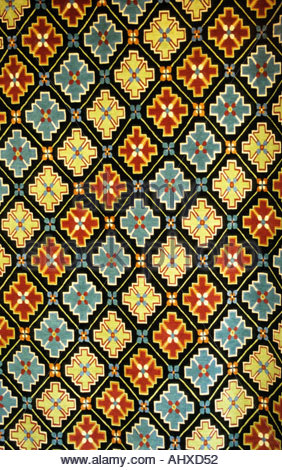 Motif géométrique complexe sur un tapis tibétain traditionnel de Boudhanath Katmandou Népal, avec des motifs croisés colorés. Banque D'Images