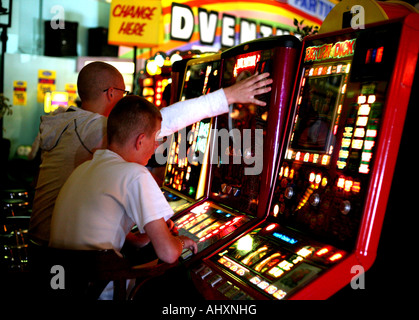 Les jeunes jouent sur les fruits dans les machines de jeux électroniques à New Brighton près de Liverpool Banque D'Images