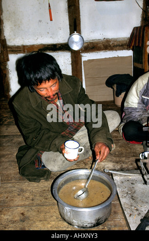 Bhoutan Bhoutan Paro de thé au beurre de yack man pouring in kitchen Banque D'Images