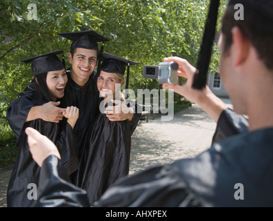 Female college graduates taking own photograph Banque D'Images