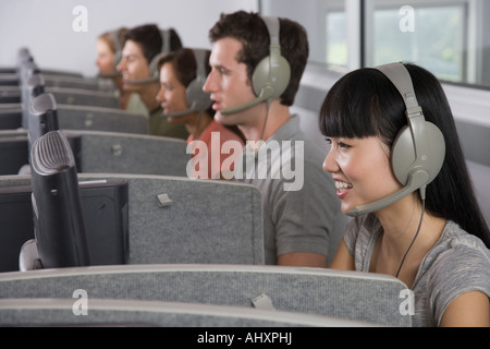 Les étudiants du Collège portant des casques in computer lab Banque D'Images