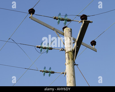 Câbles à haute tension, réunion sur un poteau télégraphique. Ciel bleu derrière Banque D'Images