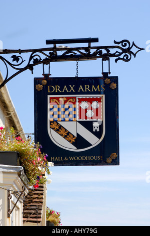 À l'enseigne de pub traditionnel bras Drax public house en Bere Regis Dorset sur un bel après-midi ensoleillé avec ciel bleu clair Banque D'Images