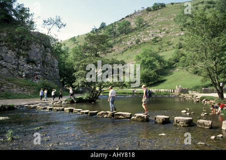 Les marcheurs crossing rivière Dove tremplin en Dovedale Peak District Banque D'Images