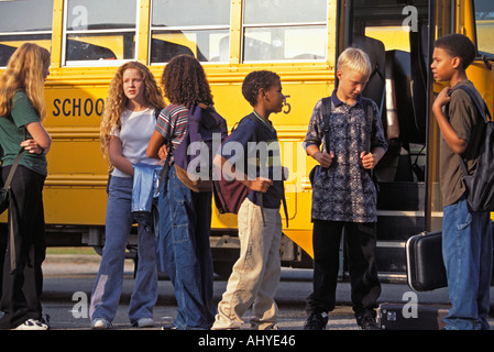 Du Caucase et de l'African American Teenage middle school students getting on school bus Banque D'Images