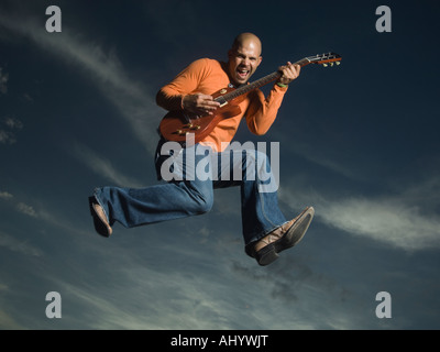 L'homme qui joue de la guitare et le saut Banque D'Images