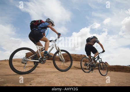 Couple riding mountain bikes in desert Banque D'Images