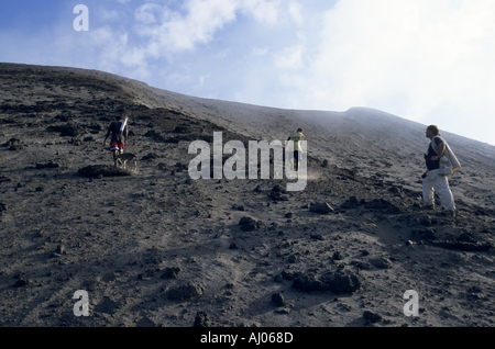 Avec deux guides touristiques locaux escalade le terrain en pente du volcan Yasur, île de Tanna, Vanuatu. Banque D'Images