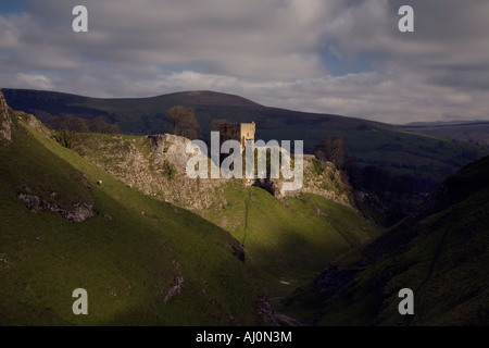 Château de Peveril baignée dans Castleton, Derbyshire, au début du printemps en vue de la grotte Dale en premier plan avec moody sky. Banque D'Images