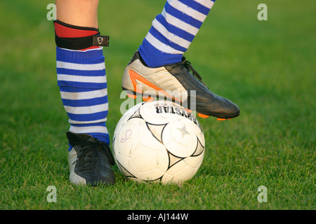 Détail d'un football et jambes habillés avec des chaussettes et des chaussures de football Banque D'Images