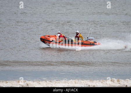 Équipage RNLI entrant dans l'eau en toute sécurité à partir de canot Banque D'Images