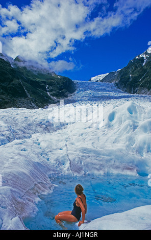 Femme la natation dans l'trou sur Fox Glacier. La Nouvelle-Zélande. Banque D'Images