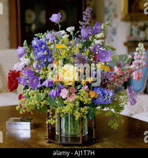 Arrangement de fleurs assorties en vase en verre avec cadre en bois. Banque D'Images