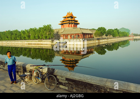 Un homme pêche dans les douves avec un reflet de la paroi de la tour du Palais de la Cité Interdite, le Musée du Palais, Pékin, Sanatorium On Gulang Island Banque D'Images