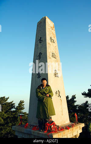 Un homme en veste de treillis verte sur un monument situé au sommet du Mont Hua, une montagne de granit (2160m) dans la province du Shaanxi Banque D'Images