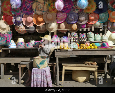Une dame à un décrochage en bordure de couleur vive vente chapeaux malgaches Banque D'Images