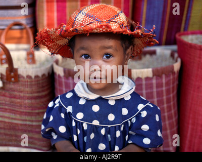 Une jeune fille à côté d'un road-side stall qui est d'offrir à la vente des paniers et des chapeaux en raphia près de Antananarivo Banque D'Images