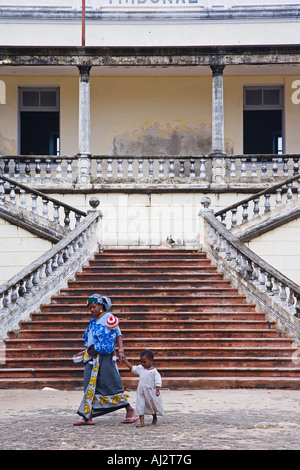 Une mère et son enfant à pied passé colonial en ruine bâtiments sur Ilha do Mozambique, autrefois la capitale de l'Afrique de l'Est Portugaise. Banque D'Images