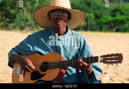 Un portrait d'un jeune homme jouant de la guitare sur la plage du lac Malawi, Malawi Banque D'Images