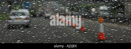 Voitures qui passent les travaux routiers sur l'autoroute dans Heavy Rain Banque D'Images