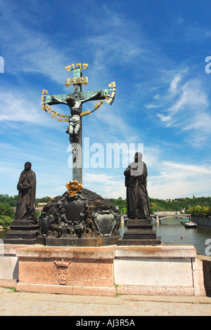 Crucifixion croix et statues de Saint Vitus sur Charles IV Bridge Prague République tchèque avec barge sur la rivière Vltava Europe EU Banque D'Images