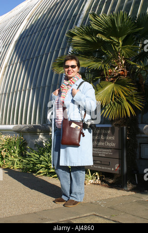 Les jeunes femmes pour l'hiver habillés en soleil tropical extérieur palm house Kew Royal Botanic Gardens Londres Banque D'Images