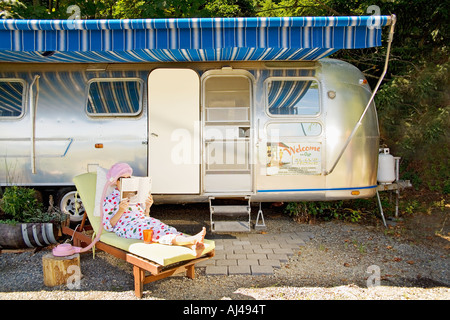 Femme lisant devant motor home Banque D'Images