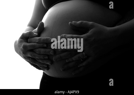 Enceinte de 8 mois femme mariée début des années 30 avec mari silhouette partielle fond blanc close up Banque D'Images