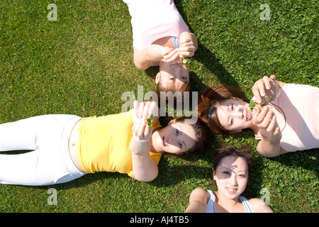 Quatre jeunes Woman lying on field Banque D'Images