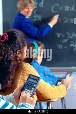 Les élèves à l'aide de calculatrices à l'école intermédiaire cours de mathématiques. Banque D'Images