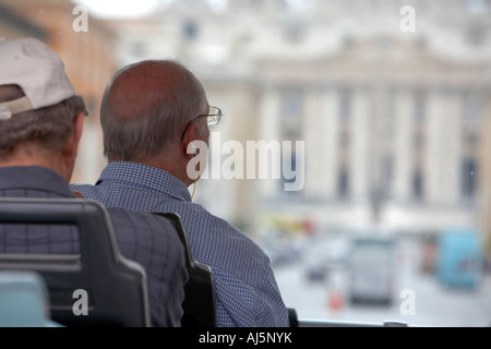 Tourist assis sur un tour à l'écoute de tour guide sur le casque à l'approche de la Basilique de St Peters Rome Lazio Italie Banque D'Images