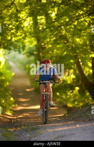 Vélo VTT femme sur un chemin de campagne verdoyante nr enfant Okeford Dorset England UK Banque D'Images