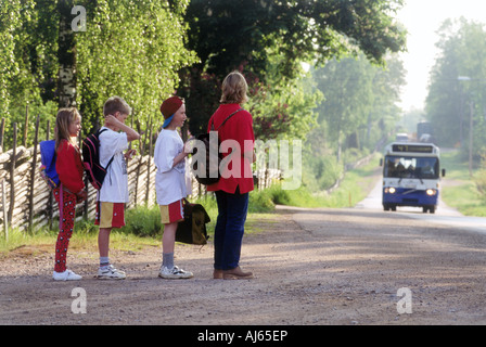 Les enfants et les parents en attente pour les autobus scolaires sur les routes de campagne en Suède Banque D'Images