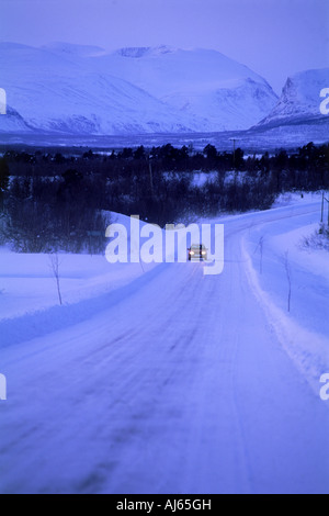 Sur la voiture en hiver en Laponie suédoise avec Kebnekaise montagnes au-dessus du cercle arctique Banque D'Images