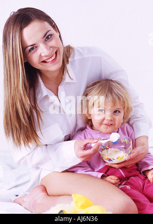 Une femme l'alimentation d'une petite fille. Banque D'Images