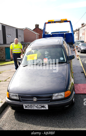 Voiture remorquée loin dans une opération de saisie DVLA véhicules garés non taxés sur l'autoroute dans le sud du Pays de Galles UK GO Banque D'Images