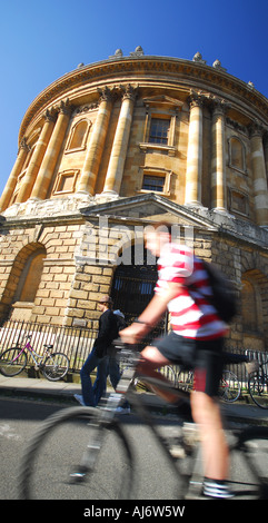 OXFORD, UK. Un étudiant du vélo au-delà de la Radcliffe Camera en Radcliffe Square. Banque D'Images