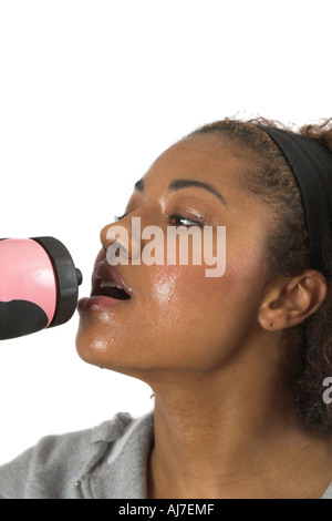 Femme avec visage en sueur d'avoir une boisson rafraîchissante après son entraînement Banque D'Images