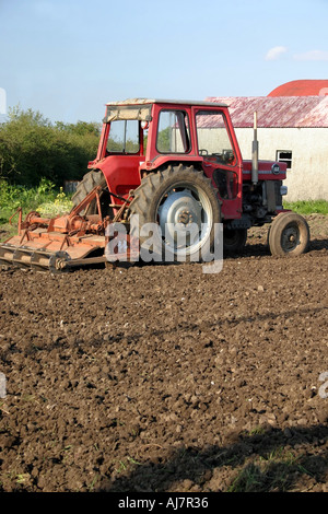 Petit vieux tracteur rouge en champ labouré, Moira, comté de Down, Irlande du Nord Banque D'Images