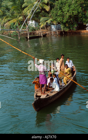 Bateau plein de passagers pôles à travers un cours d'eau dans les bras morts entre Alappuzha (Alleppy) et Kollam (Quilon), Kerala, Inde Banque D'Images