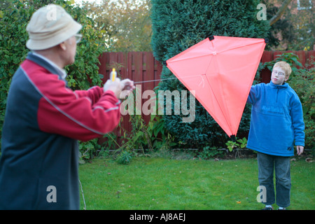 Un grand-père et son petit-fils sont flying a kite ensemble Banque D'Images