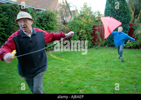 Un grand-père et son petit-fils sont flying a kite ensemble Banque D'Images