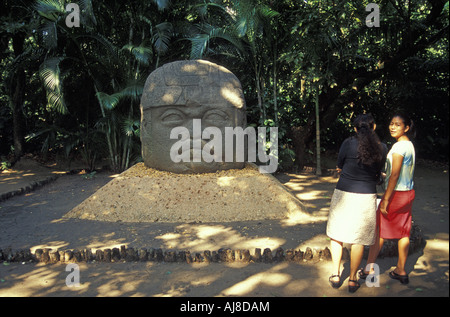 Deux jeunes femmes en face d'une colossale tête Olmèque ou Monument 1 à la Parque Museo La Venta à Villahermosa, Tabasco, Mexique Banque D'Images