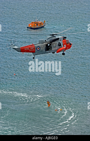 À partir d'hélicoptère RNAS Culrose et le Lézard RNLI lifeboat équipe pour la démonstration de sauvetage à Polpeor Cove à Cornwall Banque D'Images