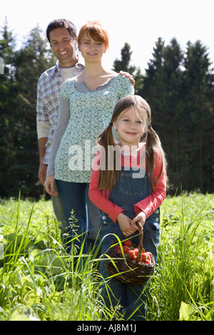 Les parents et la fille (5-6) en champ de fraises, portrait Banque D'Images