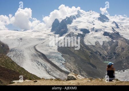 Jeune femme près de la gare de Gornergrat et le sommet du glacier du Gorner dans l'arrière-plan Zermatt Valais Suisse Juillet 2006 Banque D'Images