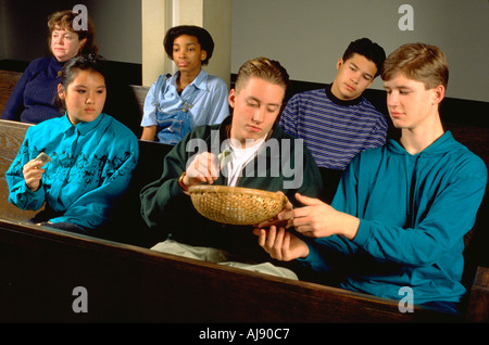 Groupe racialement mixtes des adolescents passant offrant à l'église. panier St Paul Minnesota USA Banque D'Images