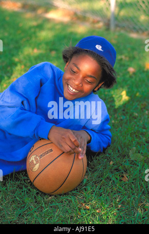 African American girl 12 ans de sourire et de se pencher sur le basket-ball. St Paul Minnesota USA Banque D'Images