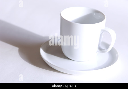 Gros plan de la tasse blanche vide et de la soucoupe sur fond blanc Banque D'Images